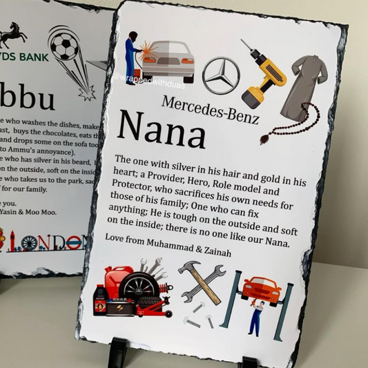A personalized slate sign for 'Nana' featuring a black background with white text, cartoon illustrations, and a Mercedes-Benz logo, displayed on a small black stand.