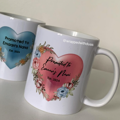 Two white ceramic mugs with custom printed heart designs and floral accents, photographed on a light neutral surface against a soft beige background.